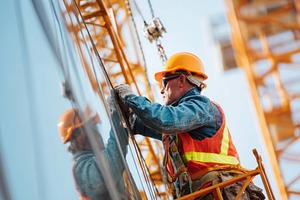 Construction worker at height on building facade, an Industrial Photo by AlyaAnd