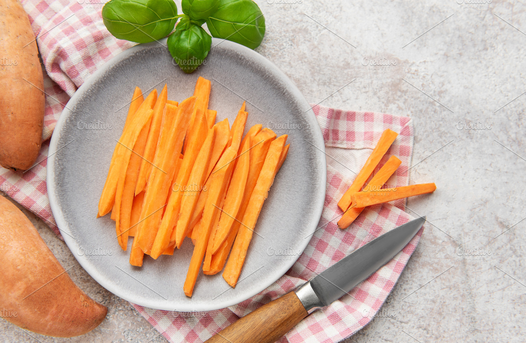 Raw sweet potato sticks on plate with basil, a Food & Drink Photo by Olena Rudo