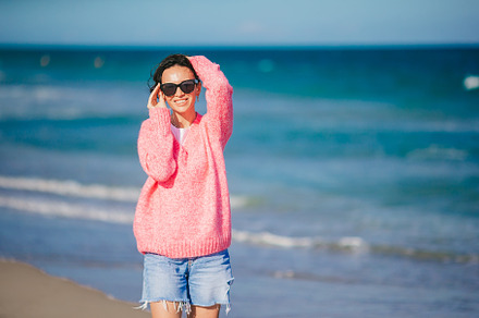 Young happy woman in cold windy weather on the beach, a Person Photo by travnikovstudio