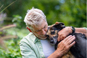 Senior man embracing loyal dog, an Animal Photo by HalfPoint