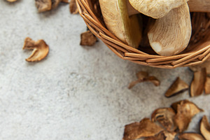 Fresh mushrooms in basket with dried mushrooms on table, a Food & Drink Photo by Olena Rudo