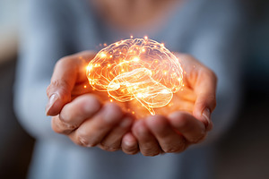 Soft glowing brain gently held in hands, symbolizing creativity and intelligenc, a Photo by AlyaAnd