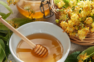 Linden honey in bowl with medicinal flowers, a Food & Drink Photo by Olena Rudo