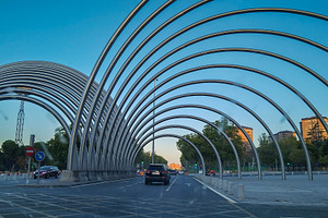 Metal arch tunnel on urban road, a Transportation Photo by DanFLCreativo