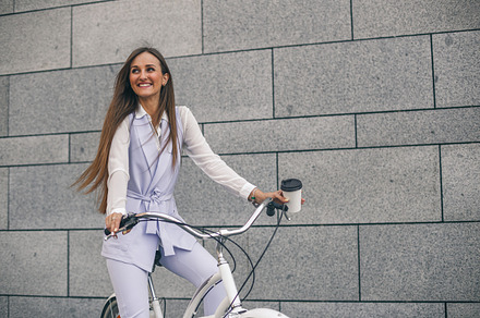 Beautiful young woman on bicycle with coffee, a Person Photo by IvanRIVER Production