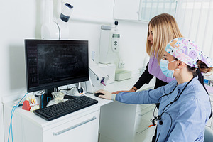 Dentist Showing Teeth X-Ray to Patient in Modern Clinic, a Health & Medical Photo by Antonio Gravante Market
