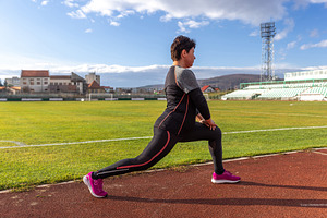 Woman stretching in lunge, a Photo by Grafvision photography