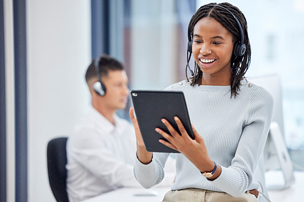 Call center woman, tablet and office for research, focus and analytics with smile, diversity and networking. Customer support, consultant and black woman in tech support, telemarketing and service, a Photo by Peopleimages.com