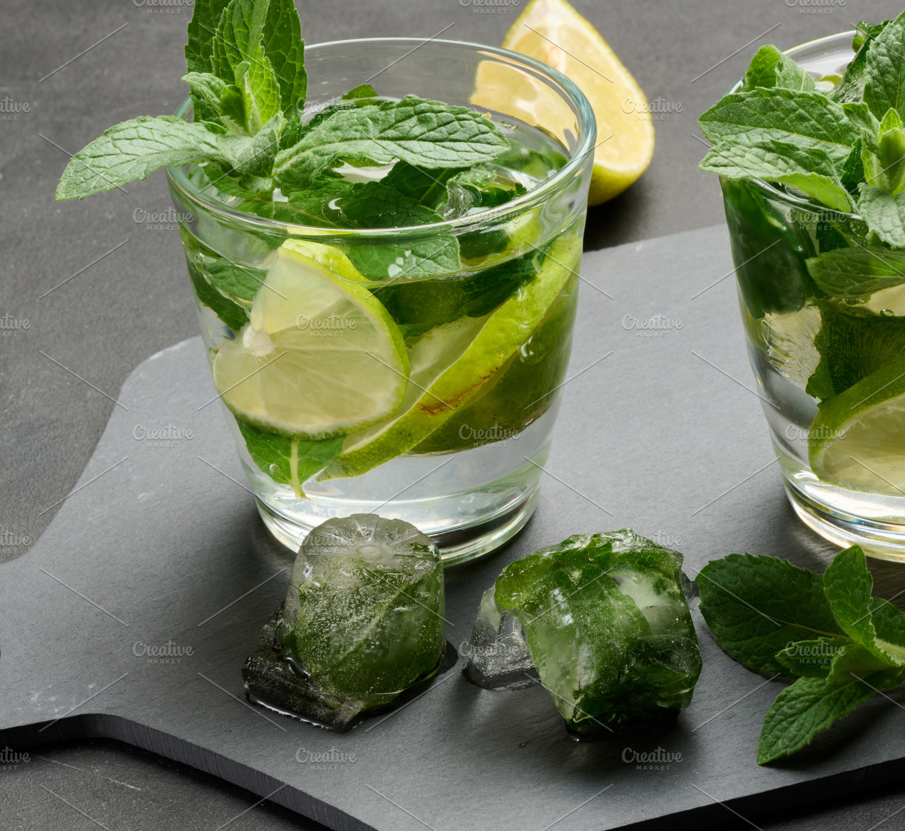 Refreshing mojito cocktail with lime, mint, and ice on dark back, a Nature Photo by ndanko