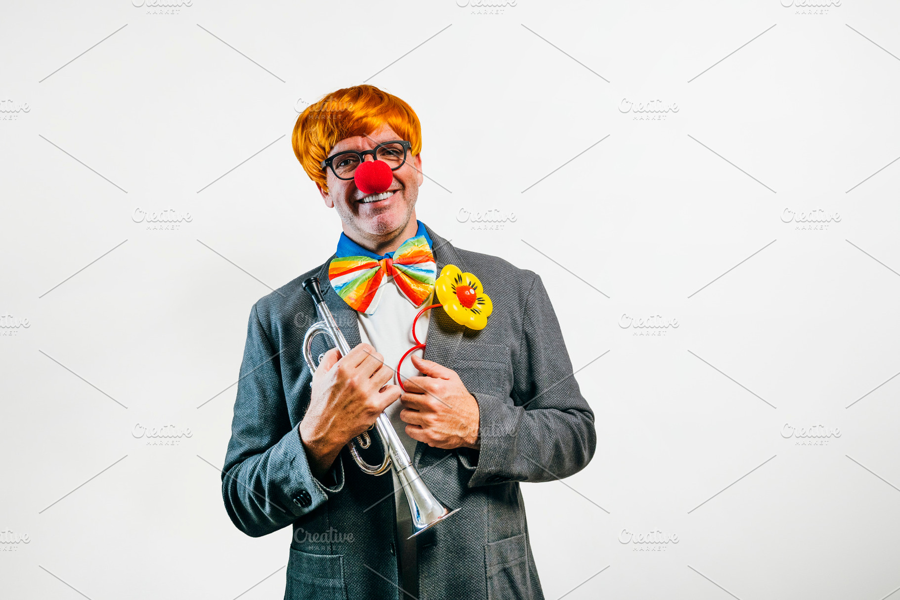 Smiling clown holding trumpet ready for performance, a Person Photo by karrastock
