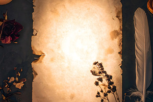 Blank illuminated parchment scroll surrounded by candles and qui, a Background Photo by GoodGoods