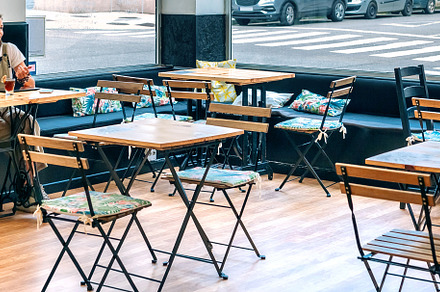 Man and woman working in a coffee shop maintaining social distancing, a Person Photo by davidpereiras