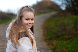 Portrait of a cheerful young girl walking on a path in nature, w, a Person Photo by Ales Munt