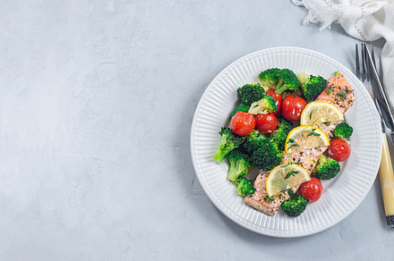 Baked salmon fillet with broccoli and tomato on plate, horizontal, top view, co, a Food & Drink Photo by iuliia_n