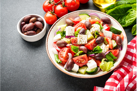 Greek salad in craft plate on black