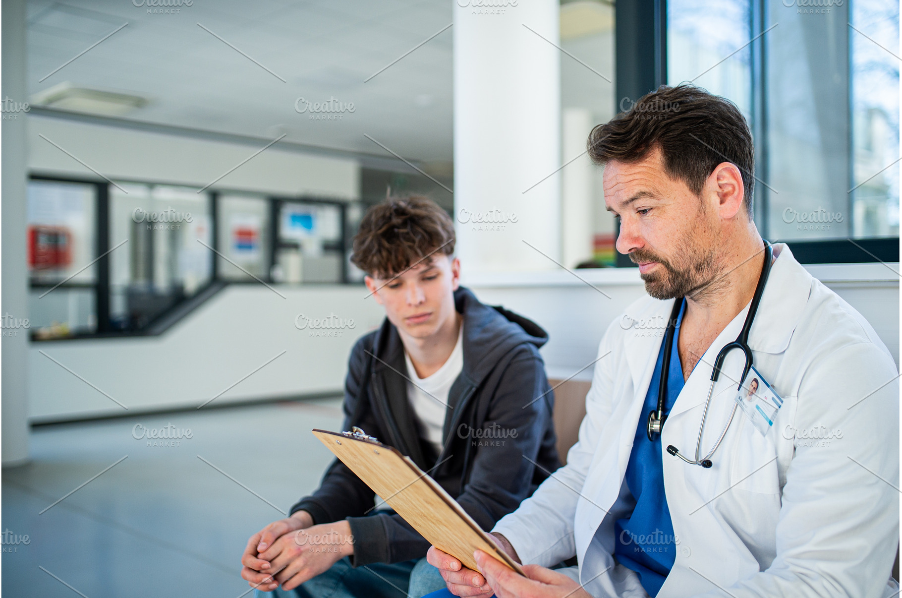 Doctor talking with teenage patient, a Person Photo by HalfPoint