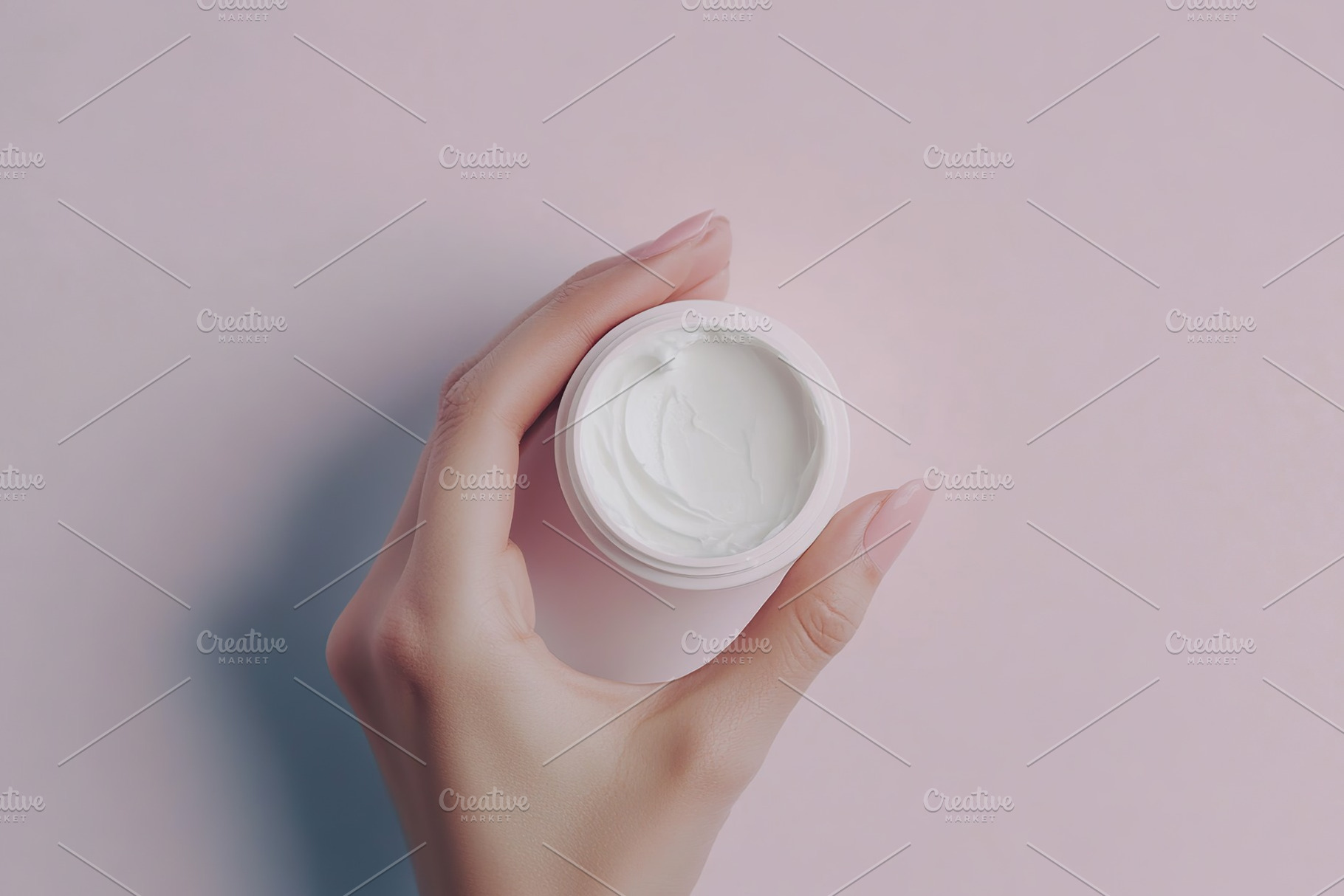 Female model hand holding cosmetic jar on pink background, a Photo by AlyaAnd