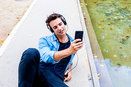 Man listening to music by a pond., a Person Photo by RF Images