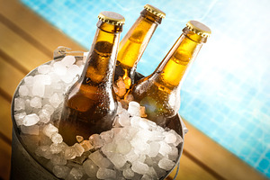 Beers in ice buckets on the edge of the pool, a Food & Drink Photo by Davizro's Market