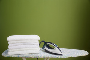 White towels, iron, and olive green wall, a Photo by Alliance Images