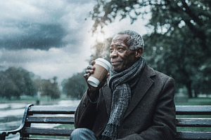 Elderly black man enjoying hot coffee in park, a Person Photo by DanFLCreativo