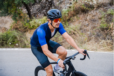 Cyclist riding up a mountain pass on, a Sports & Recreation Photo by Xavi Bosch Stock