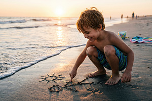 Child Drawing in Sand at Sunset Beach, a Sports & Recreation Photo by Davizro's Market