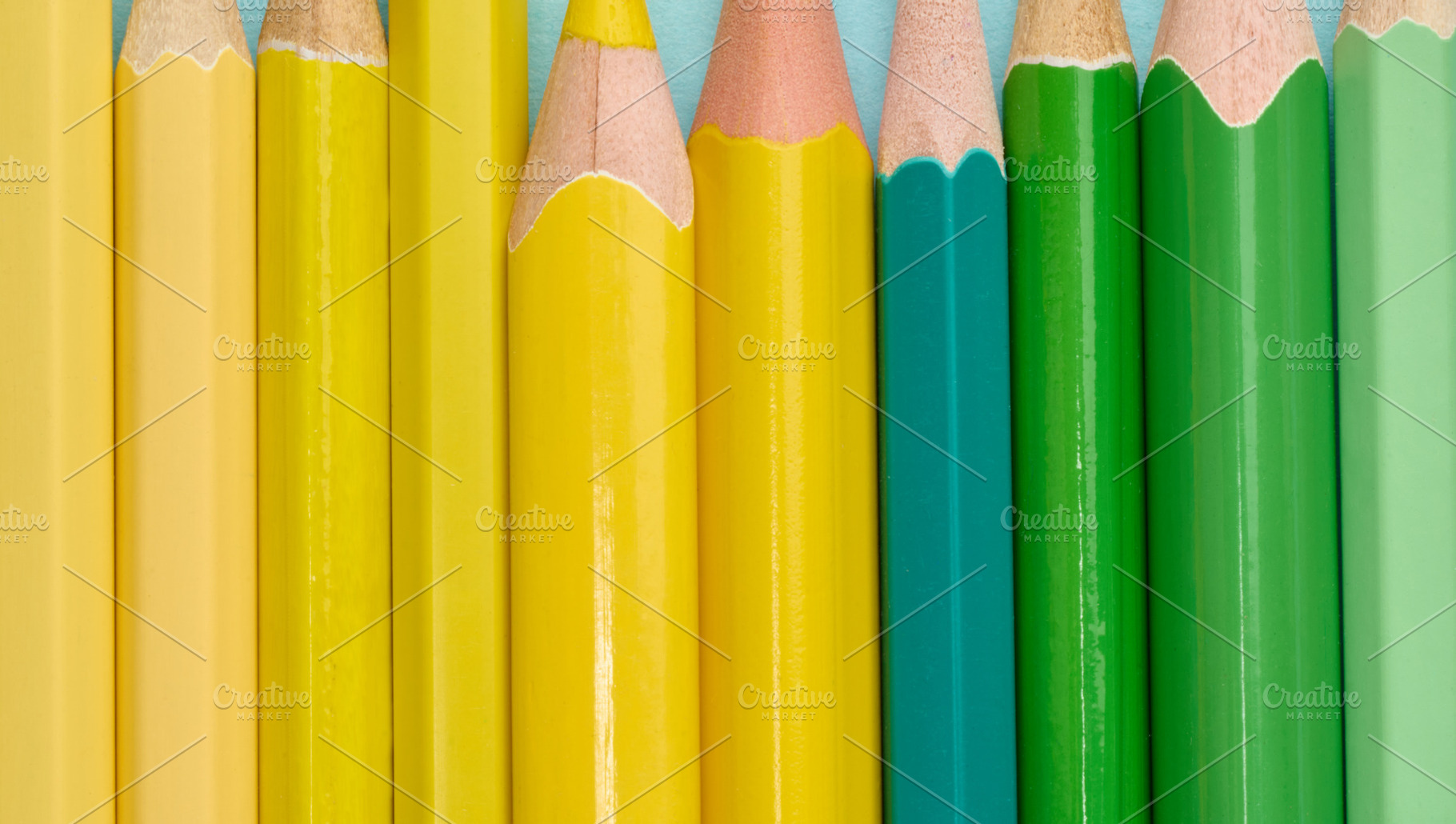 Close-up of a row of green and yellow wooden pencils, a School & Education Photo by ndanko