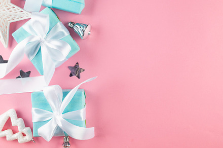Holidays gift box wrapped in blue paper, balls, glitter on pink, a Holiday Photo by vimart