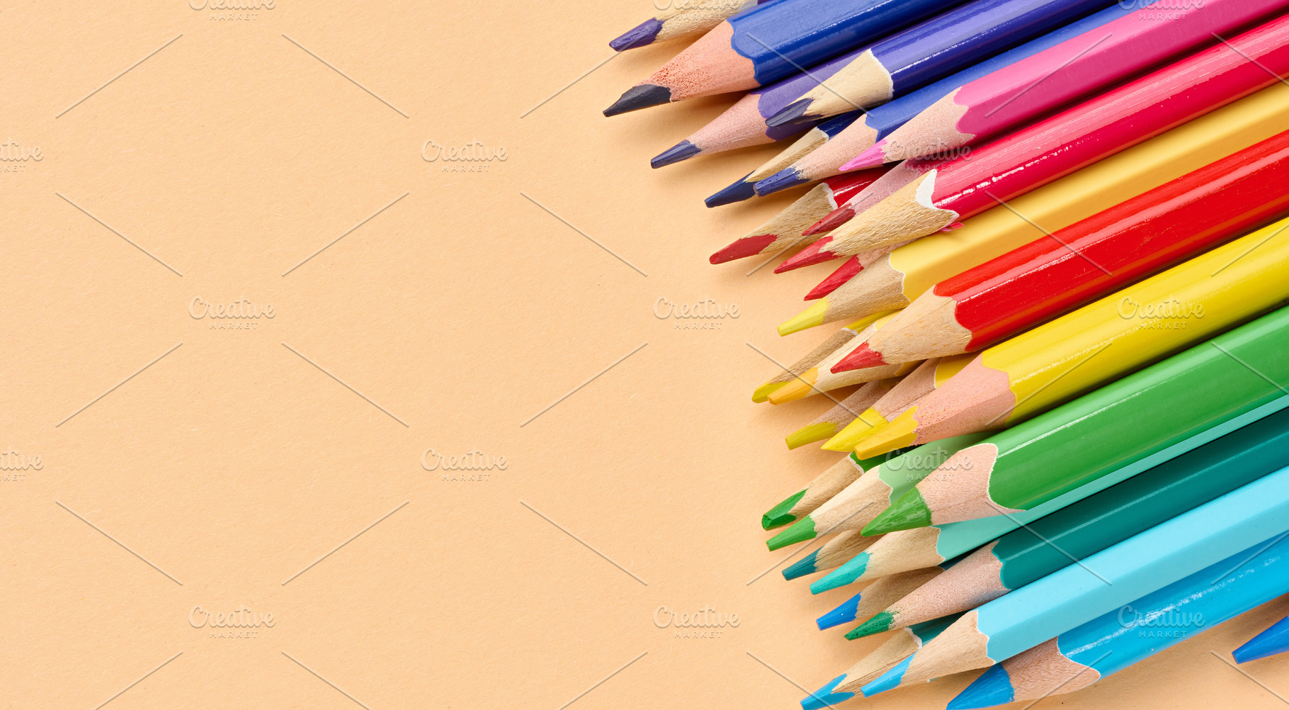 Multicolored wooden pencils stacked on a beige background, a School & Education Photo by ndanko