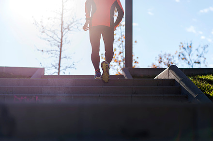 Active senior man climbing stairs in outdoor park sunlight