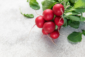Fresh organic radishes with green leaves on light background, a Food & Drink Photo by Olena Rudo