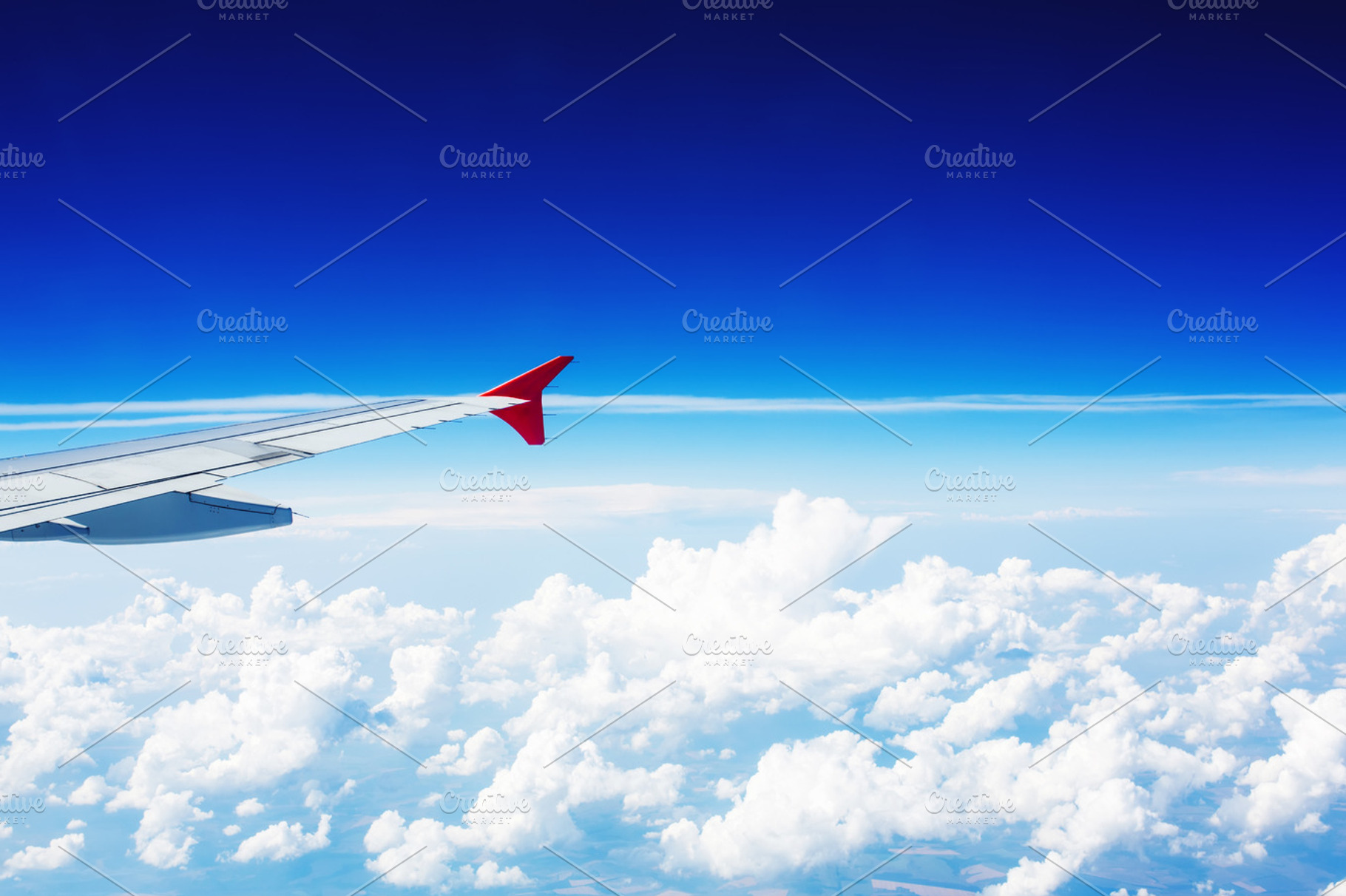 Wing of an airplane above clouds containing wing, airplane, and cloud, a Transportation Photo by odpium