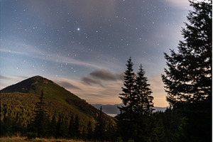 Starry night over mountain peak with, a Nature Photo by Stockphoto by vzwer