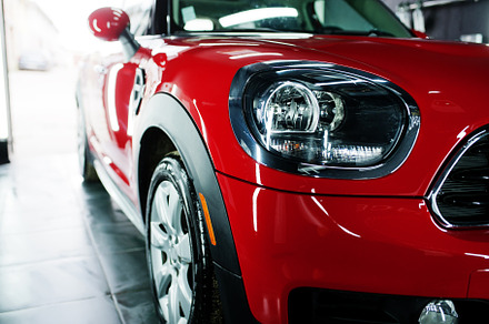 Headlights and hood of sport red car in garage., a Transportation Photo by AS photostudio