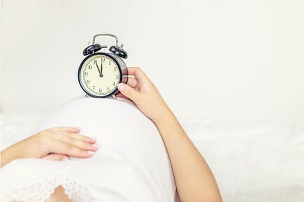 The pregnant woman holds an alarm, a Person Photo by yanadjana