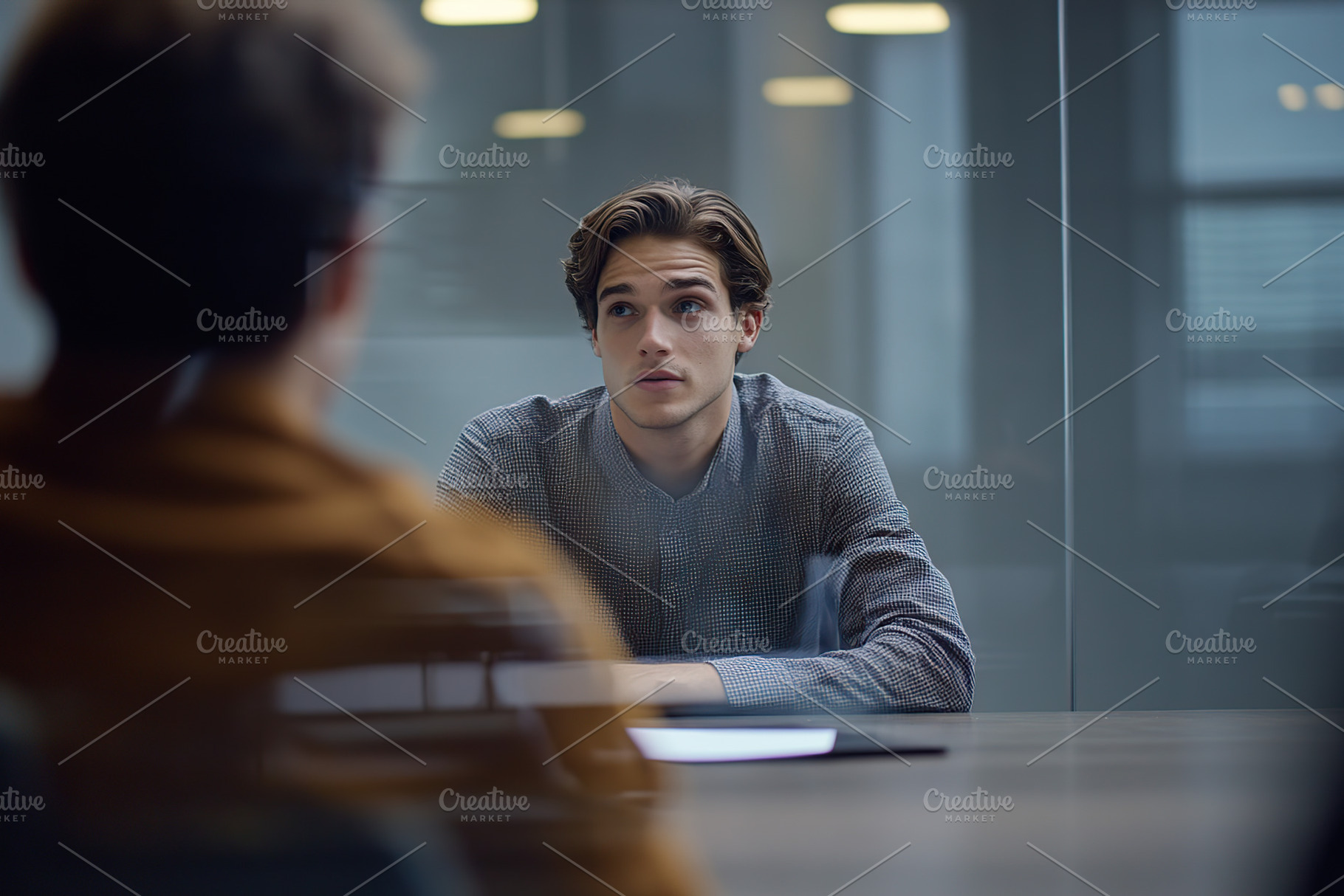 Young man engaged in serious conversation during a business meeting, a Photo by AlyaAnd