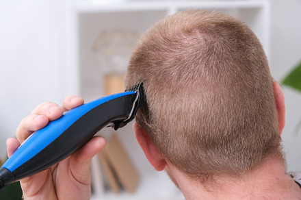 A man cuts his hair with clipper. Cutting a short hairstyle at home. Close-up., a Technology Photo by Detriana