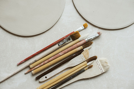 Ceramics in pottery workshop set featuring tools, pottery, and glaze