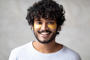Modern beauty products. Portrait of handsome indian man with golden patches und, a Person Photo by Prostock-Studio
