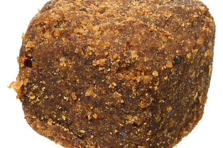 Brown dog snack or treat with a textured, crumbly surface, isola