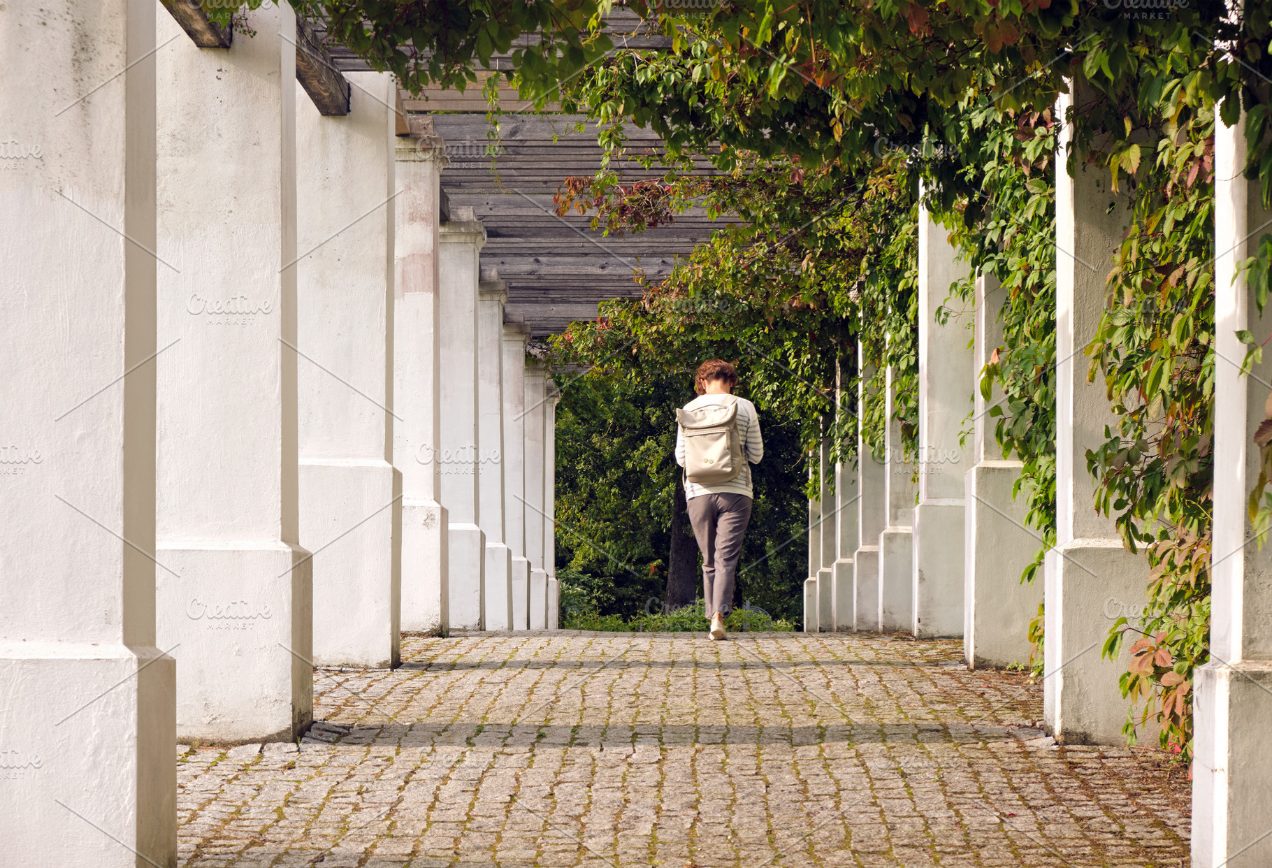 Woman walking away in outdoor alley, a Person Photo by BOOCYS