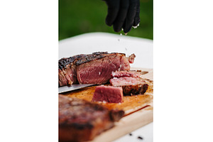 Chef slicing juicy grilled steak on, a Food & Drink Photo by HalfPoint