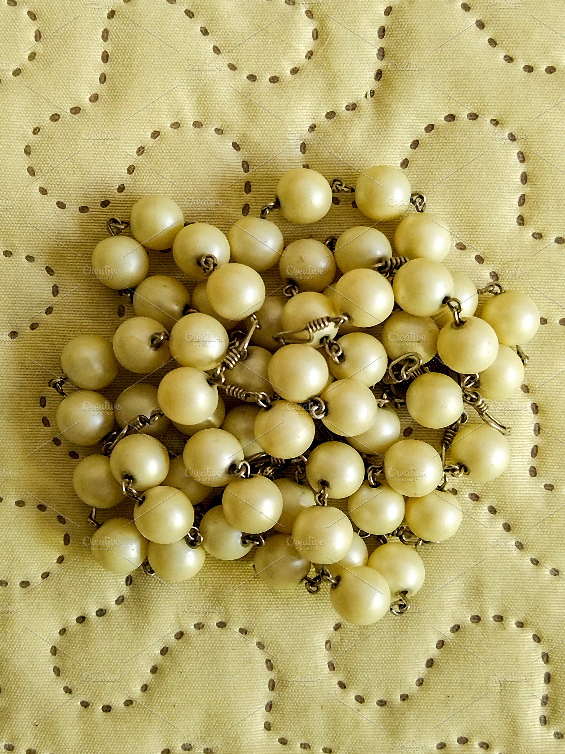 Rosary bead on embroidered fabric, an Arts & Entertainment Photo by DanFLCreativo