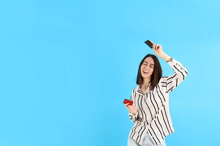 Attractive woman with cards on blue background, a Person Photo by AtlasStudio PRO