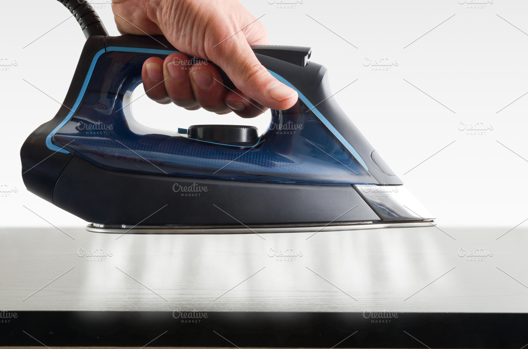 Hand operating steam iron and jets coming out on tabvle, a Technology Photo by Davizro's Market