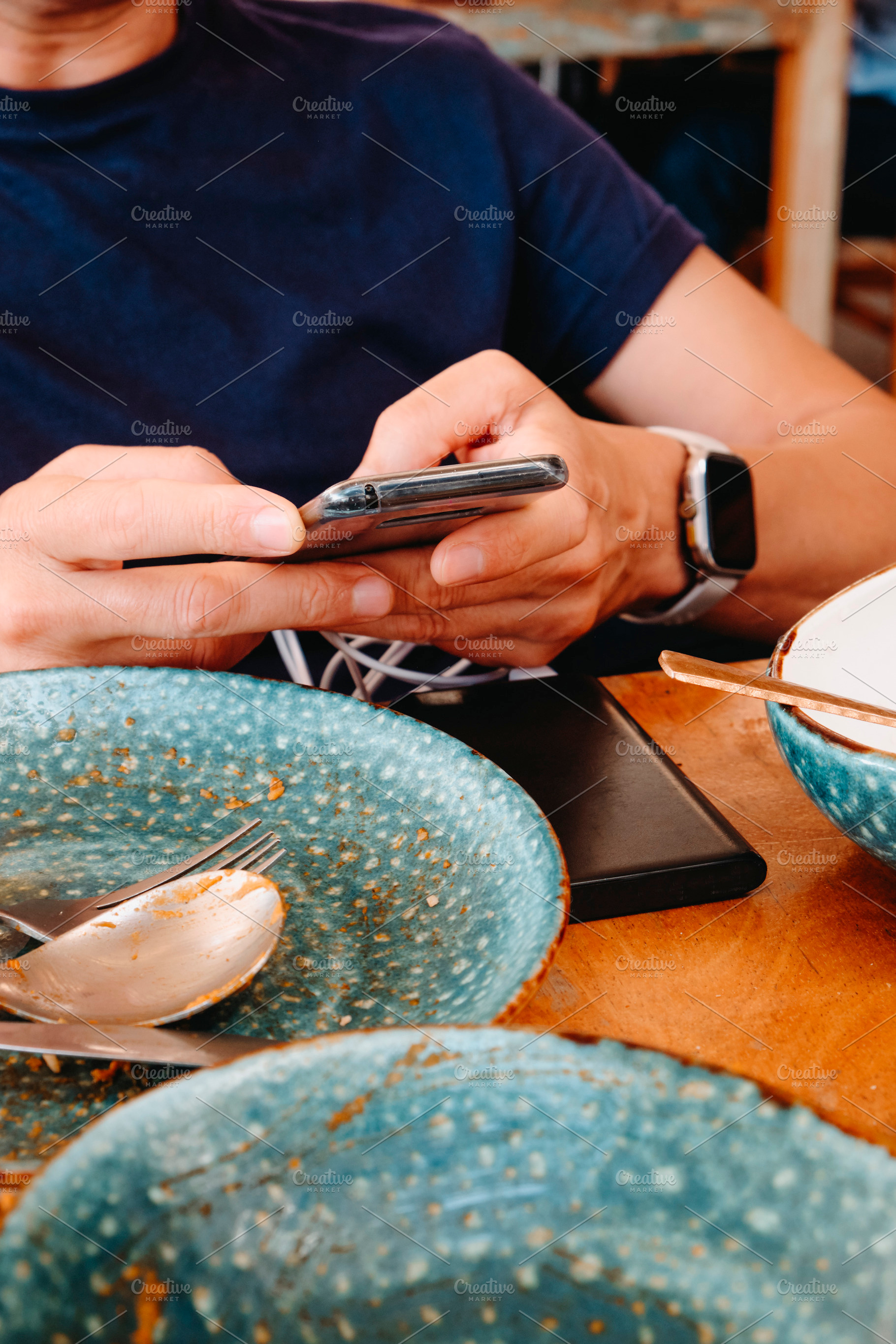 a man uses a phone connected to a power bank, a Photo by Nito