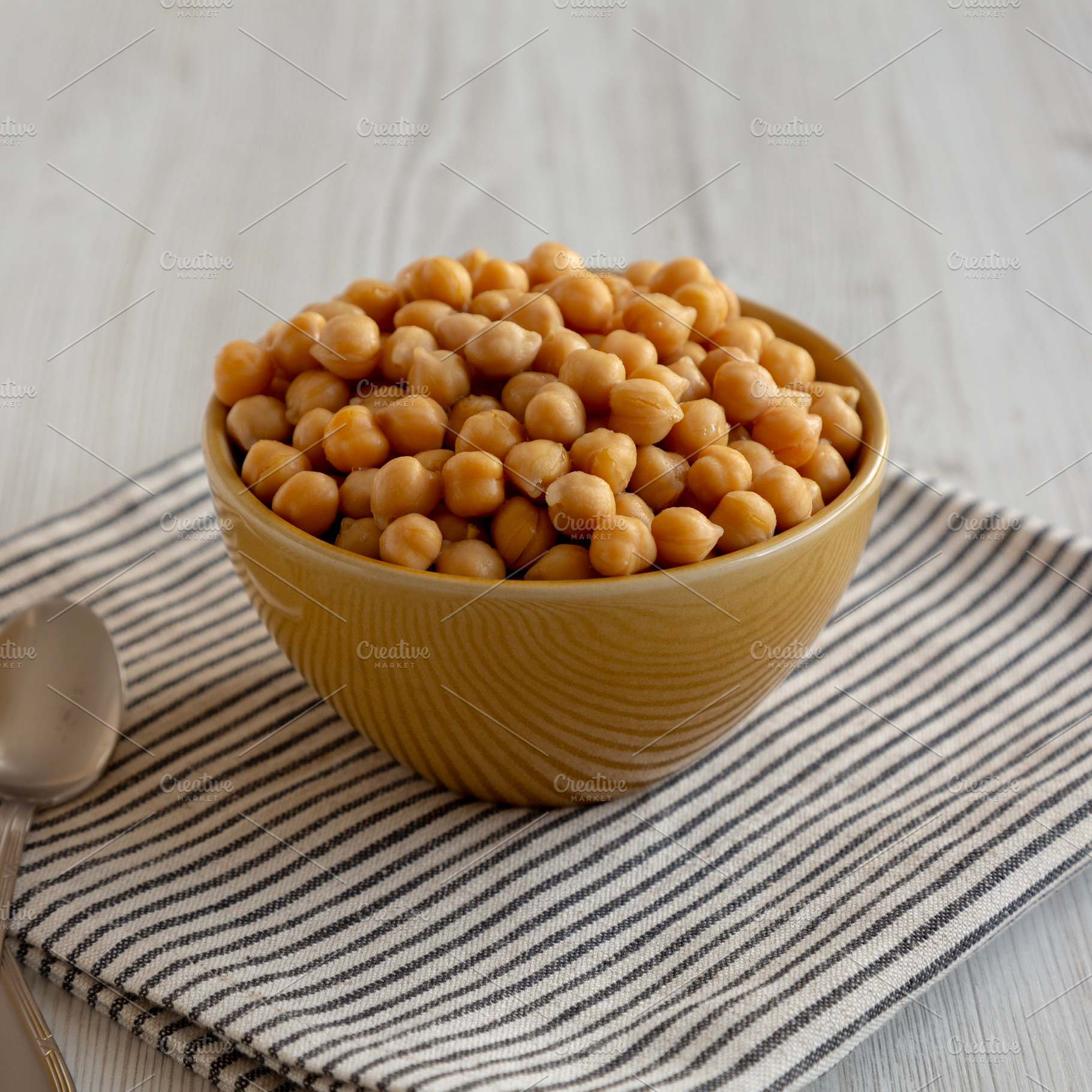 Organic Raw Canned Chickpeas in a Bowl, low angle view., a Food & Drink Photo by LiudmylaChuhunova
