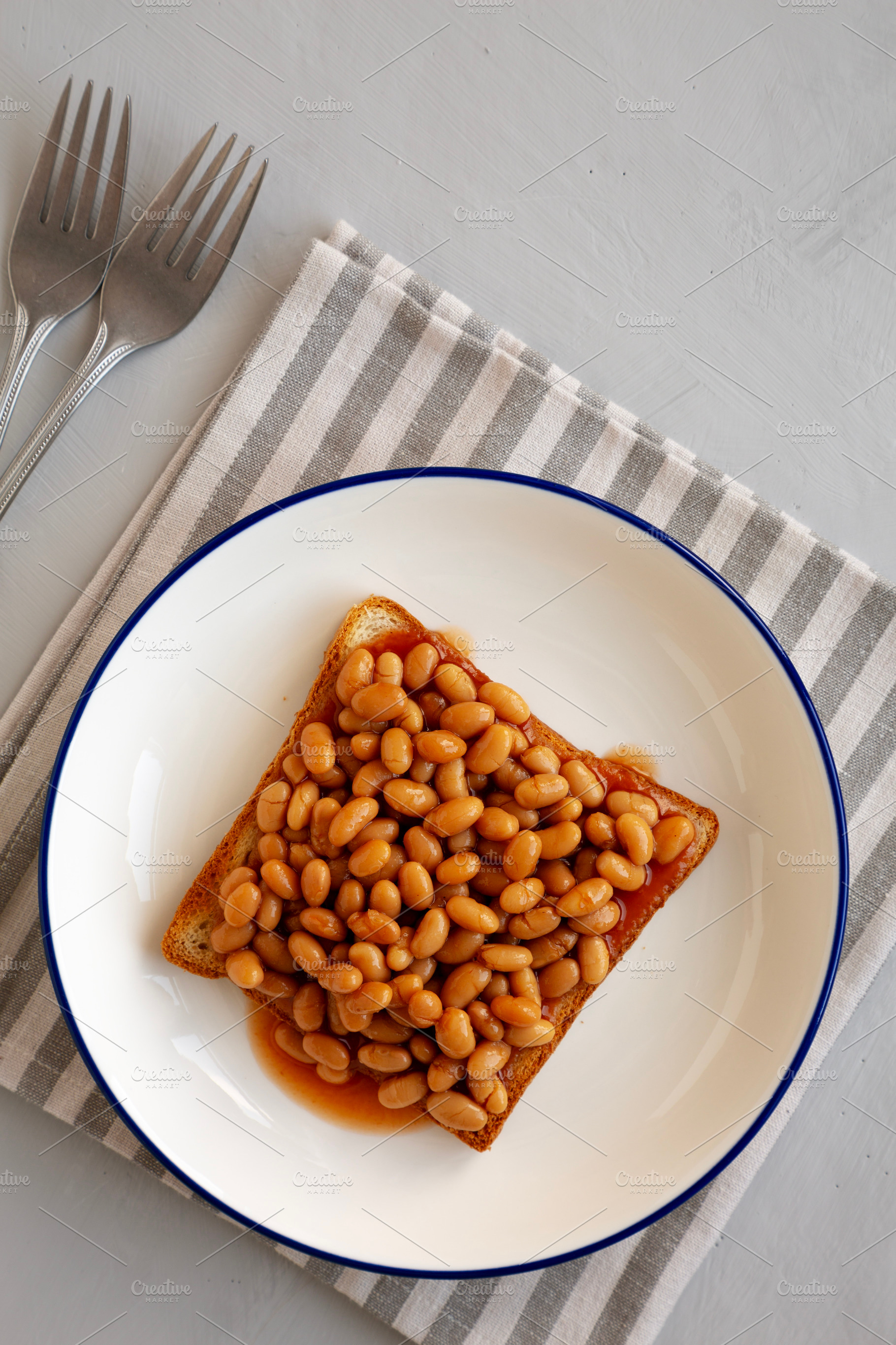 Homemade English Beans on Toast, top view. Overhead, from above,, a Food & Drink Photo by LiudmylaChuhunova