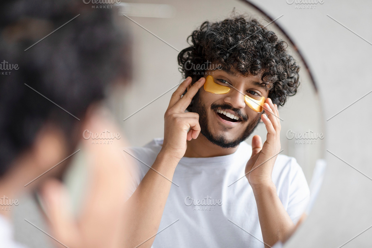 Portrait of indian man applying eye patches on his face and looking at mirror a, a Photo by Prostock-Studio (Photo 3 of 5)